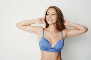 Young mother in blue brassiere feels confident in her body after breast lift.